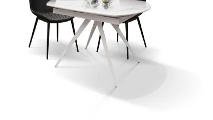 Tavolo allungabile sagomato con top in ceramica e basamento centrale in metallo finitura bianca